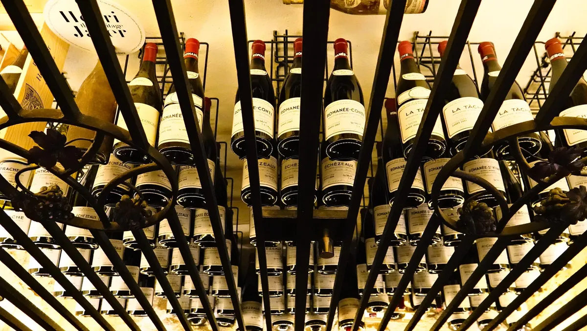 Des bouteilles de vin sont entreposées dans une cave à vin métallique avec des étagères inclinées