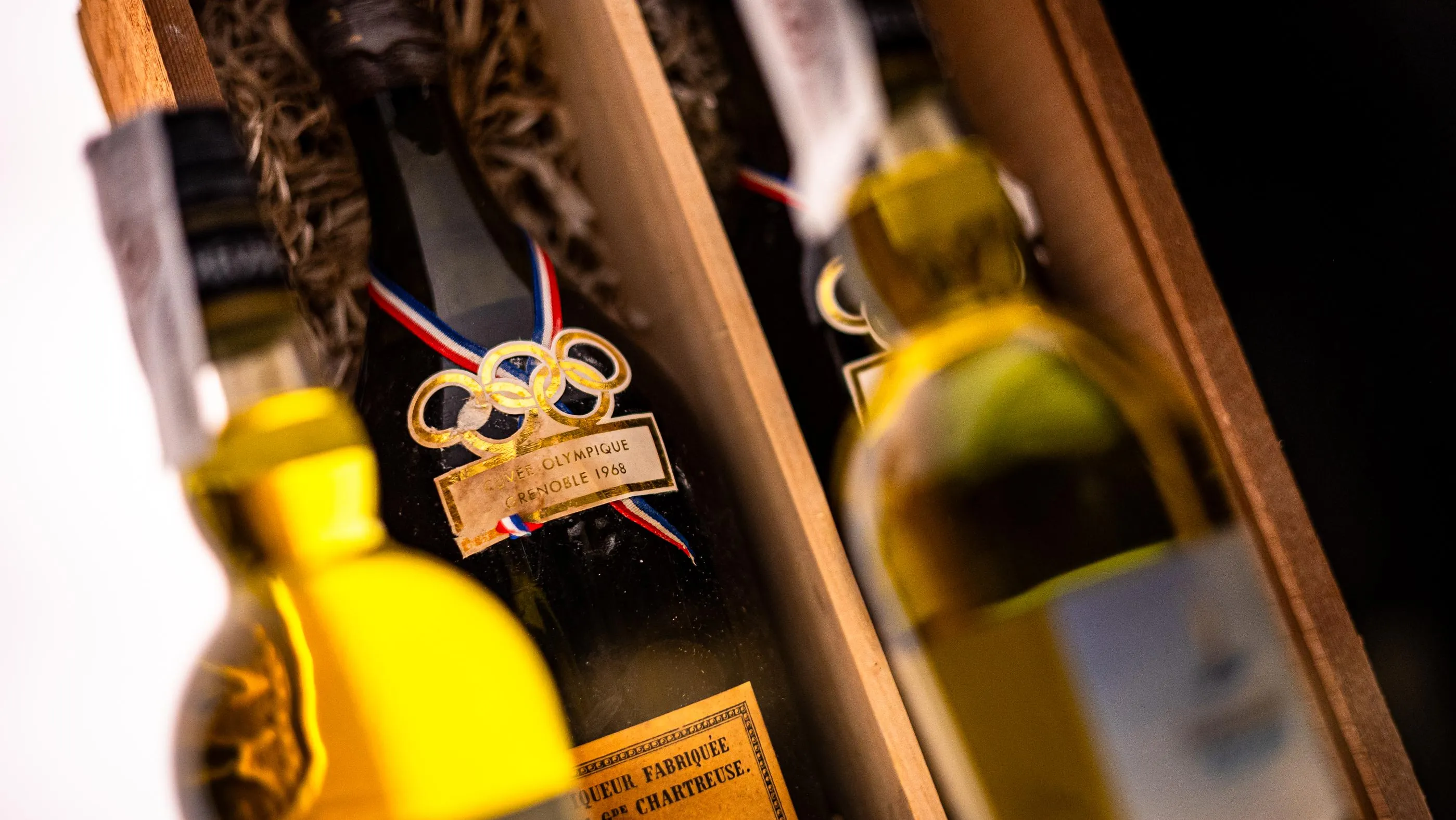 Médailles olympiques avec rubans tricolores et bouteilles de liqueur en arrière-plan