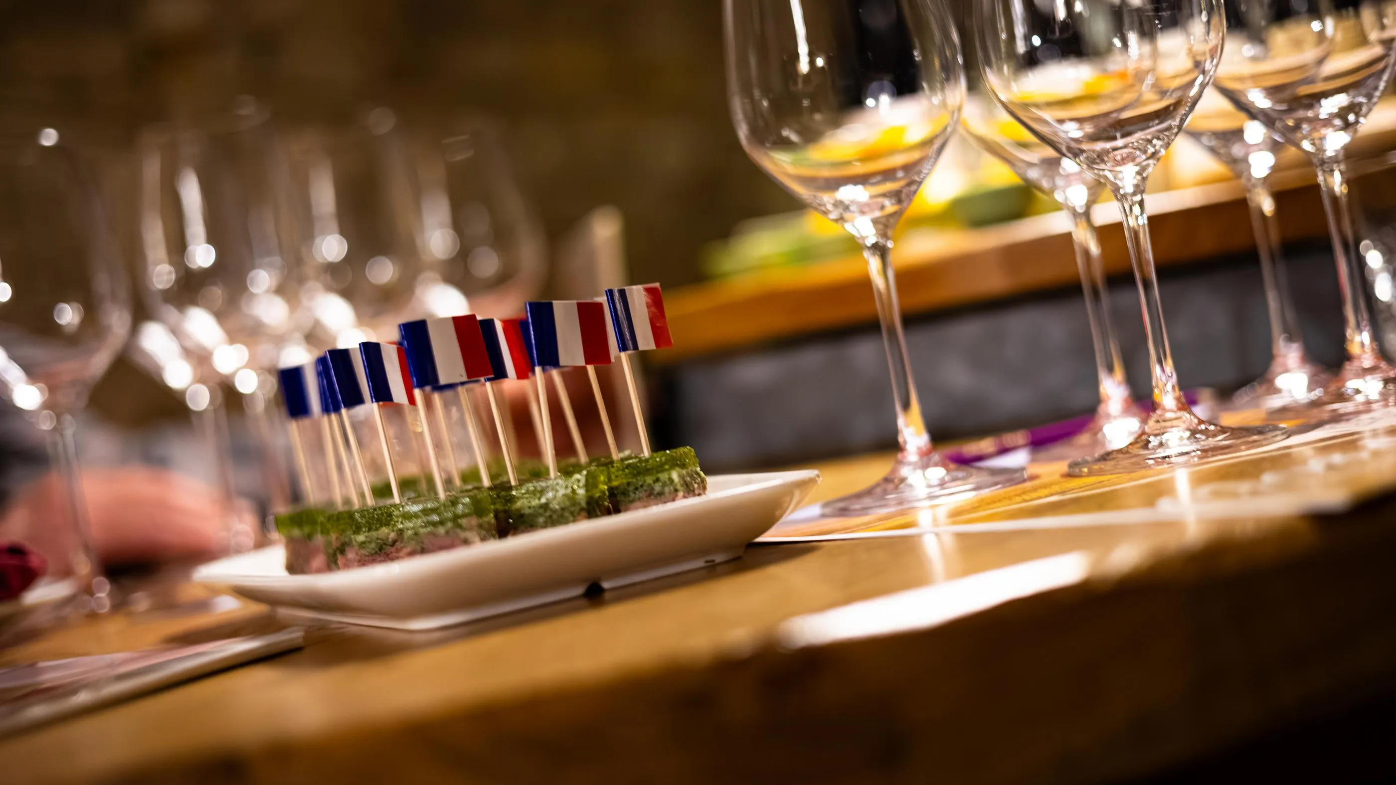 Wine glasses and small French tricolor flags on a table