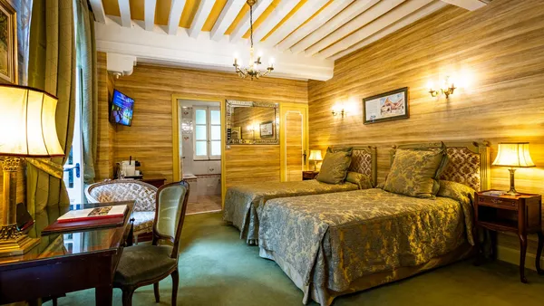 Bedroom with double bed, bedside table, desk, television and wooden walls