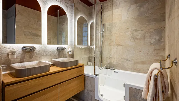 Salle de bain avec deux vasques en pierre, un bain à remous et une douche à l'italienne, le tout dans un style moderne et élégant