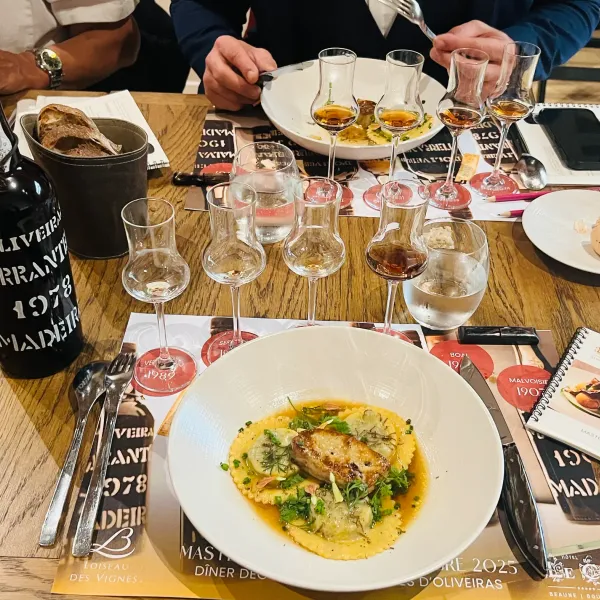 A table with wine glasses, a bottle, food plates, and brochures