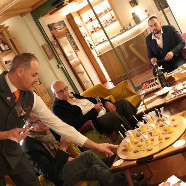 A group of people sitting in a wine bar tasting wine samples and chocolates.