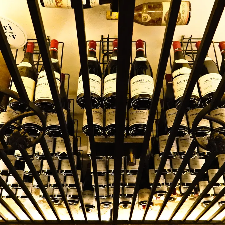 Des bouteilles de vin sont entreposées dans une cave à vin métallique avec des étagères inclinées